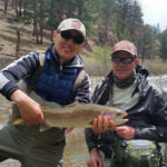 A angler holdiing a large rainbow trout, with his fly fishing guide Chris Galvin.