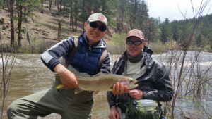 A angler holdiing a large rainbow trout, with his fly fishing guide Chris Galvin.