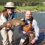 Female teen fly fisherman poses with guide, Chris Galvin, with a large cutbow trout.