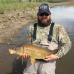 All smiles as this fly fisherman holds a healthy common carp.